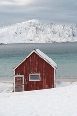 Isolated Red Cabin by Snowy Lake