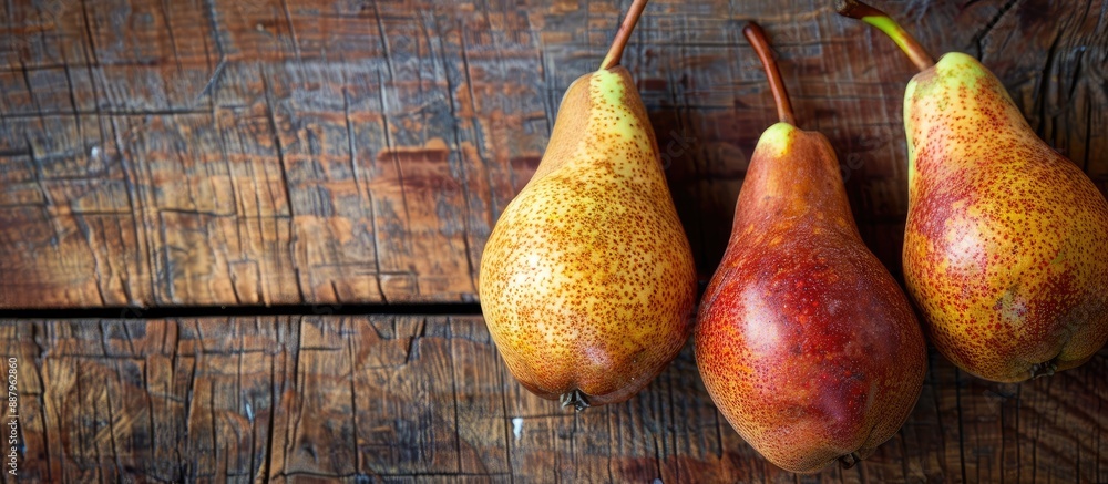 Poster selective focus highlights three fresh pears on a wooden background with a blank area for text or im
