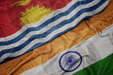 waving colorful flag of india and national flag of Kiribati on the dollar money background. finance concept.