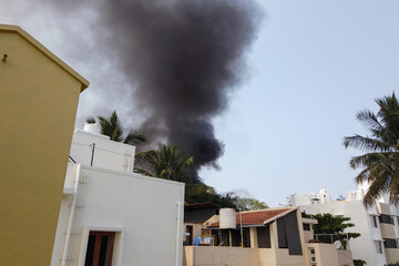 Thick black Smoke bellowing out of a Residential building due to an accidental fire in suburbs of Mysuru in Karnataka, India..