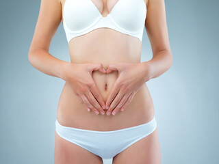 Girl, hands and stomach for diet in studio on white background with underwear. Female person, isolated and belly or waist with tummy tuck for self care with gut health, weight loss and wellness