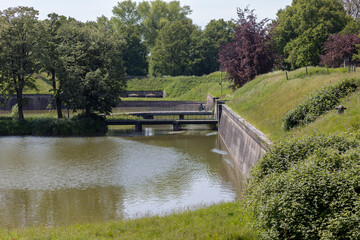 Naklejka premium Reinforced walls of Naarden Vesting in the Netherlands with armory and retaining wall embedded in part of protective dike structure Dutch Waterlinie infrastructure