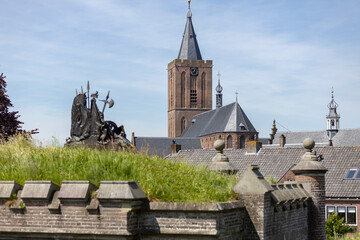 Church tower towering behind reinforced city wall stronghold water dike of Naarden Vesting in The...