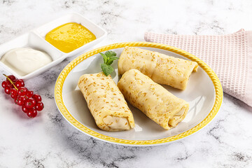 Homemade stuffed pancakes with honey and cream sour