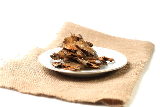 Fried salted fish or ikan asin sepat (Trichopodus trichopterusis) is a famous dish in Indonesia. Isolated and copy space on white background.