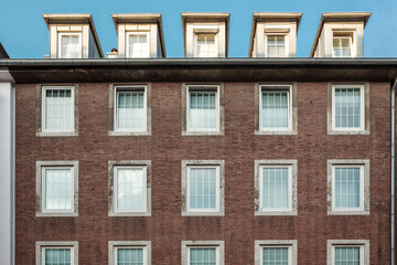 Fototapeta premium Modern Brick Building Facade with Windows and Dormers
