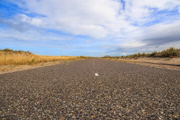 path over the dunes to the beach in the Netherlands in Petten aan Zee on a windy day with cloudy...
