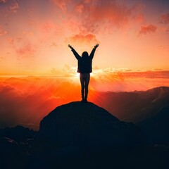 Silhouette woman standing on mountain looking at sunset...Feeling motivated and successful.