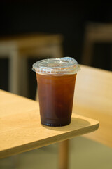 Americano in a clear cup on wood.