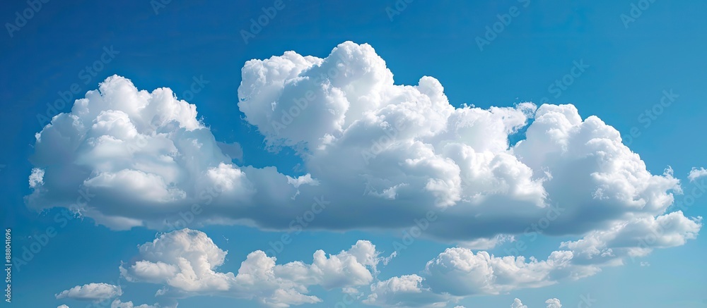 Aufkleber puffy white clouds floating in a clear blue sky with ample copy space image