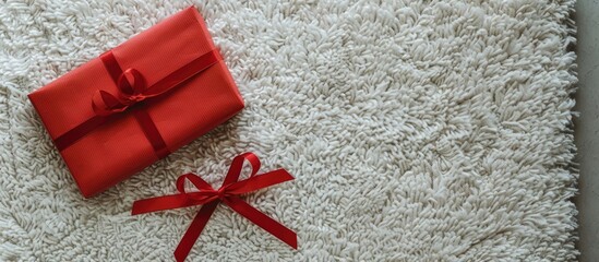 A festive red letter and Christmas gift displayed on a white carpet with ample copy space image