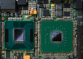 Detailed closeup of an electronic circuit board showcasing microchips, resistors, and other...