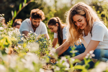 A group of people, volunteers, are planting new trees in the park. Caring for the environment. World Earth Day. World Volunteer Day.
