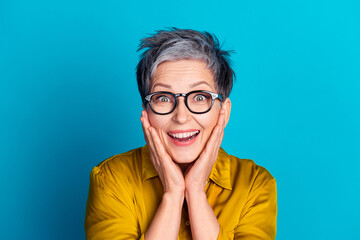 Photo of cheerful excited woman wear blouse spectacles smiling arms cheeks isolated blue color background