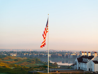 American flag blowing in the wind with morning skies
