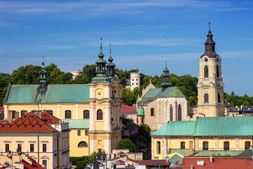 Obraz premium Top view from Clock Tower of Museum of Bells and Pipes on Cathedral of St. John the Baptist and Cathedral Basilica of Przemysl, Poland. Przemyśl Castle on the background