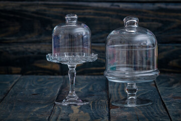 Glass cloche bells on a rustic wooden surface representing elegant kitchen decor and display items.