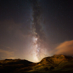 Milky Way shining over a mountain landscape under a starry sky