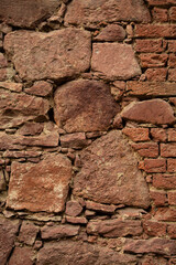 Close up. Old red wall made of various sizes  stone and bricks. Background or texture. 