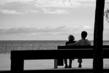 couple sitting on bench at the beach