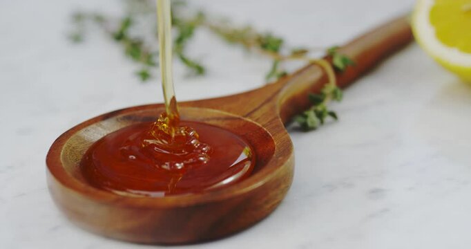 Drizziling orange honey into spoon rotating shot