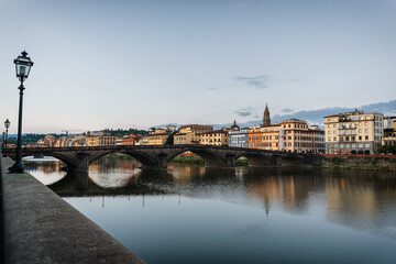 Fototapeta premium Summer morning in Florence. Ponto Vecchio and the historic center. People go jogging at dawn and there are no tourists.