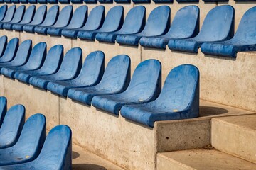 Obraz premium long rows of blue seats on a sports field stand