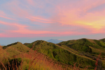Hills and meadow at dawn with dramatic colorful sky. Nature concept with copy space for additional text or elements.
