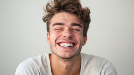 Obraz premium A professional portrait studio photo of a handsome young white american man model with perfect clean teeth laughing and smiling. isolated on white background