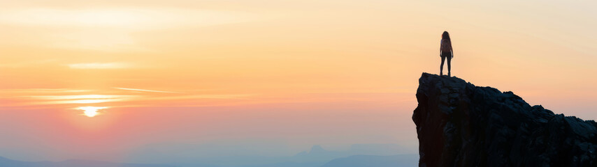 Fototapeta premium Hiker at the summit of a mountain overlooking a stunning valley landscape