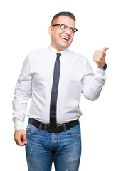 Middle age bussines arab man wearing glasses over isolated background smiling with happy face looking and pointing to the side with thumb up.