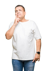 Middle age arab man wearig white t-shirt over isolated background with hand on chin thinking about question, pensive expression. Smiling with thoughtful face. Doubt concept.