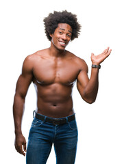 Afro american shirtless man showing nude body over isolated background smiling cheerful presenting and pointing with palm of hand looking at the camera.