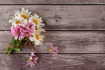 Bouquet of chamomile and mallow flowers on wooden background, summer banner for product advertising, abstract floral arrangement, rustic style, holiday card, selective focus..