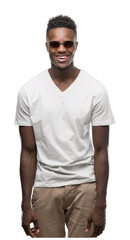 Fototapeta premium Young african american man wearing sunglasses with a happy face standing and smiling with a confident smile showing teeth