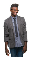 Young african american business man over isolated background looking away to side with smile on face, natural expression. Laughing confident.