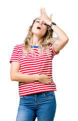Beautiful young blonde woman over isolated background surprised with hand on head for mistake,...