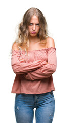 Beautiful young blonde woman over isolated background skeptic and nervous, disapproving expression...