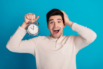 Portrait of nice young man alarm hand touch head wear pajama isolated on blue color background