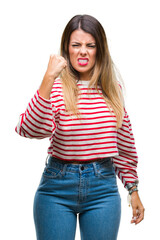 Young beautiful woman casual stripes winter sweater over isolated background angry and mad raising fist frustrated and furious while shouting with anger. Rage and aggressive concept.