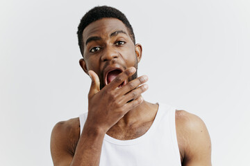 Surprised african american man with wide open mouth expressing astonishment on a plain white...