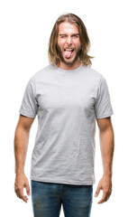 Fototapeta premium Young handsome man with long hair over isolated background sticking tongue out happy with funny expression. Emotion concept.