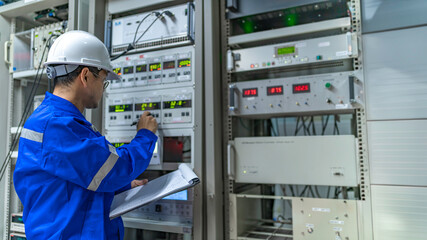 Electrical engineer woman checking voltage at the Power Distribution Cabinet in the control...