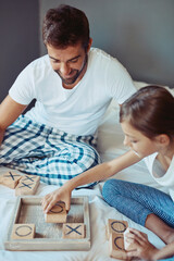 Father, child and playing a board game on bed for bonding, problem solving or educational...