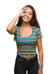 Young beautiful arab woman over isolated background doing ok gesture with hand smiling, eye looking through fingers with happy face.