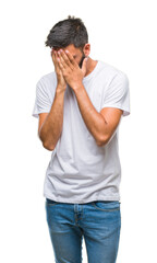 Adult hispanic man over isolated background with sad expression covering face with hands while...