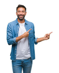 Adult hispanic man over isolated background smiling and looking at the camera pointing with two hands and fingers to the side.
