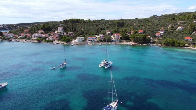 Drone view of yachts moored on buoys near the shore in the bay of Uvala Gradina near the town of Vela Luka on the island of Korcula in Croatia