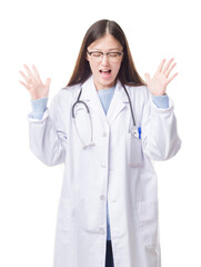 Young Chinese doctor woman over isolated background celebrating mad and crazy for success with arms raised and closed eyes screaming excited. Winner concept