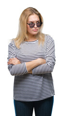 Naklejka premium Young caucasian woman wearing sunglasses over isolated background skeptic and nervous, disapproving expression on face with crossed arms. Negative person.